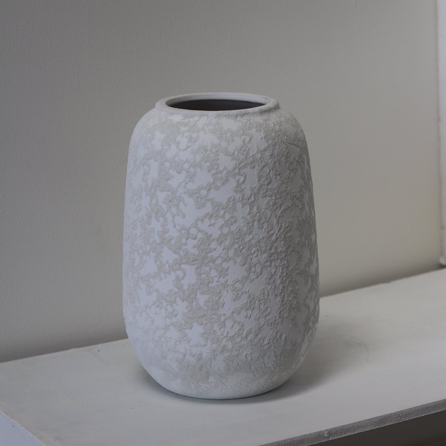Textured gray vase against a plain wall